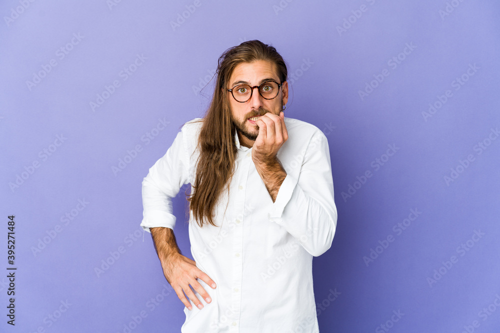 Young man with long hair look biting fingernails, nervous and very anxious. Young man with long hair look biting fingernails, nervous and very anxious.
