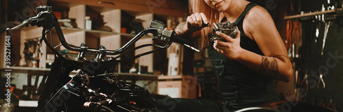 Woman mechanic repairing a motorcycle in workshop