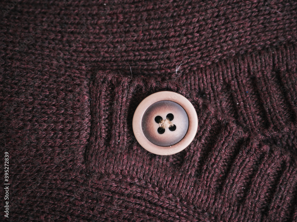 Macro snapshot of knitted texture. Warm sweater. Fashion and texture concept with button in the middle Macro snapshot of knitted texture. Warm sweater. Fashion and texture concept with button in the middle