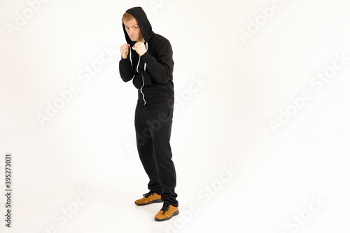 Full length shot of attractive caucasian adult male wearing black training outfit and boxing photo