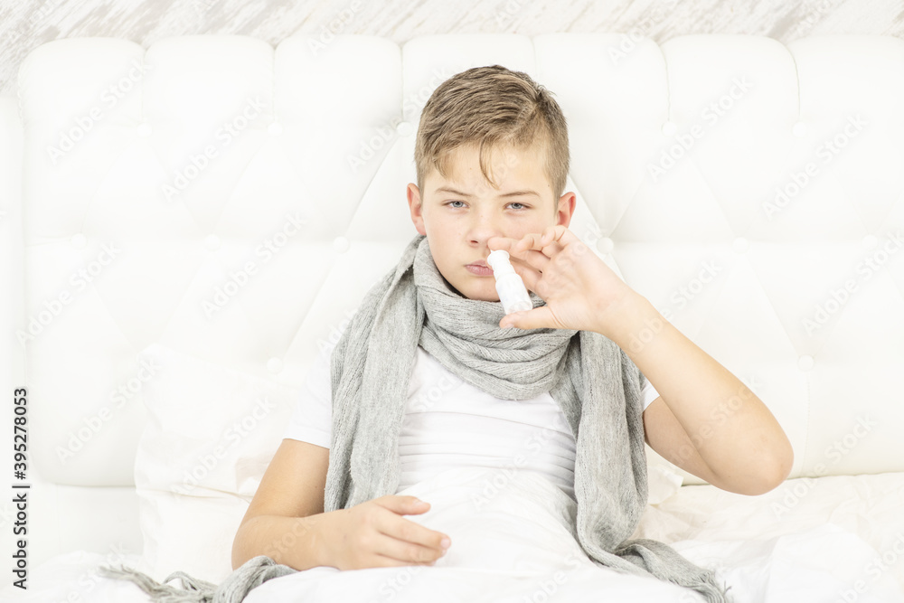 Sick teen boy washing his nose with medicine while sitting on bed at home Sick teen boy washing his nose with medicine while sitting on bed at home