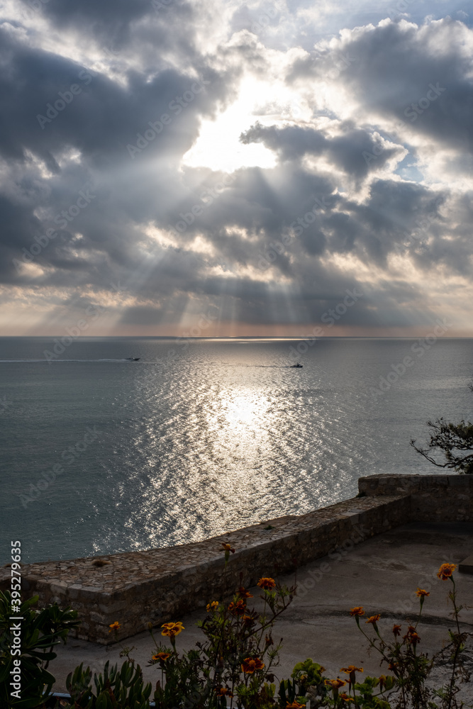 
A great ray of sun breaks through the clouds and hits the sea.