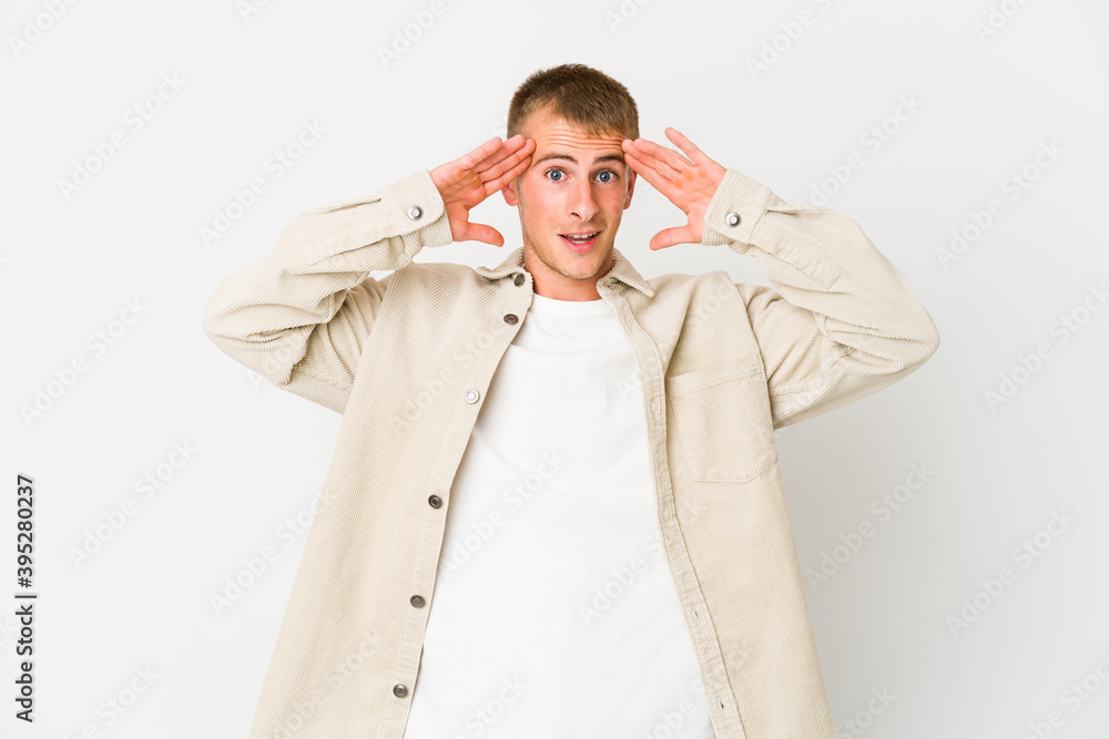 Young caucasian handsome man receiving a pleasant surprise, excited and raising hands. Young caucasian handsome man receiving a pleasant surprise, excited and raising hands.