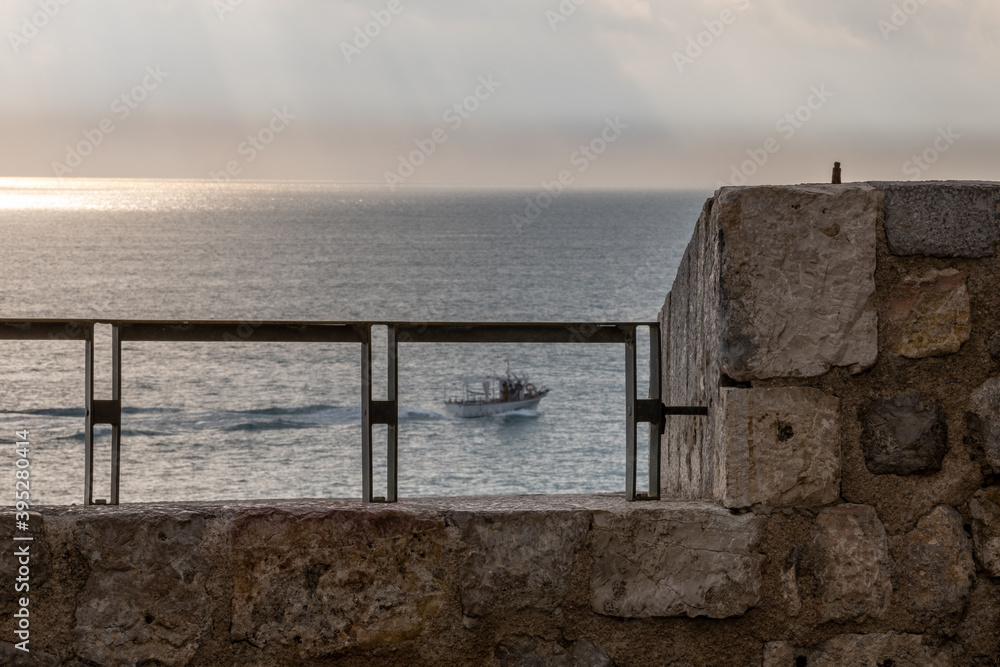 
In the morning, a fishing boat returns from work with a calm sea. View from the castle walls