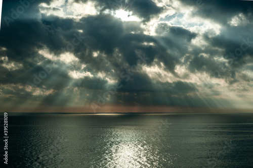  A great ray of sun breaks through the clouds and hits the sea.