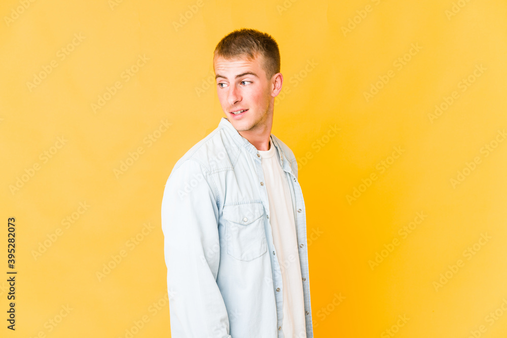 Young caucasian handsome man looks aside smiling, cheerful and pleasant. Young caucasian handsome man looks aside smiling, cheerful and pleasant.