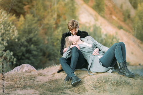 A young girl is lying on her boyfriend's lap. The couple looks at each other. Outdoors. Portrait of the General plan. The concept of love, happiness, and romantic relationships. Valentine's day. © Anna Shnaider