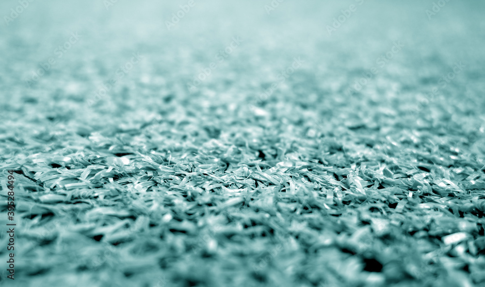 Cyan color artificial grass close-up with blur background Cyan color artificial grass close-up with blur background