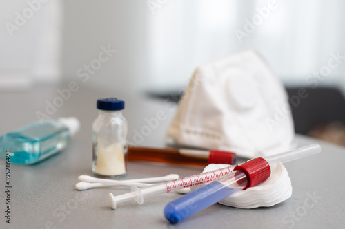 Syringes, medicine bottles on a gray background.
