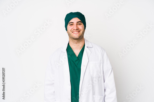 Young surgeon man isolated on white background happy  smiling and cheerful.