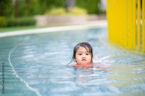 Little girl in swimming suit playing at waterpark. © tienuskin
