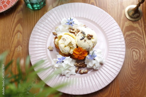 Ice cream with nuts and raisins and whipped cream. Culinary photography. Food styling.