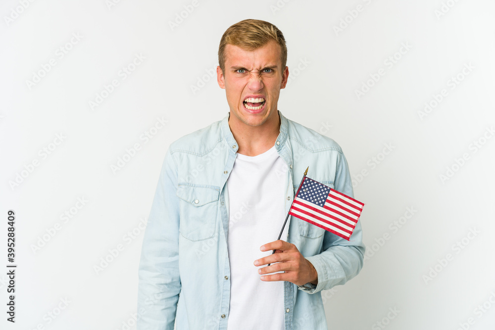 Young caucasian man holding a american flag isolated on white background Young caucasian man holding a american flag isolated on white background