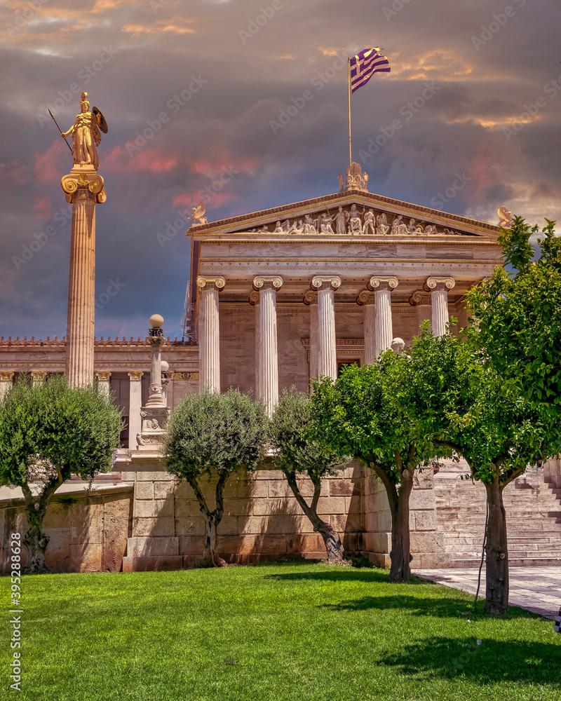 The National academy of Athens classic building with Athena and Apollo statues under dramatic sky, Athens Greece