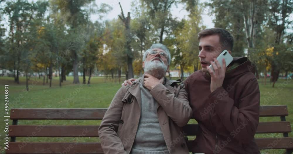 Stranger calling emergency service, helping senior man suffering from chest pain Stranger calling emergency service, helping senior man suffering from chest pain