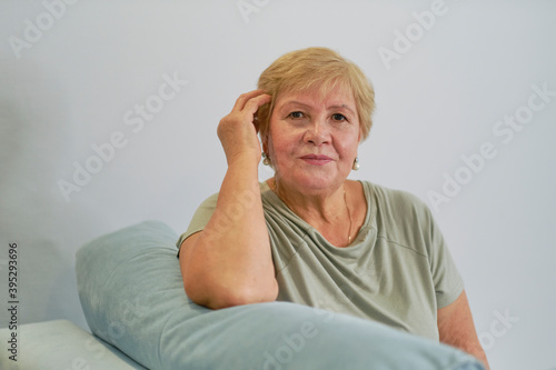 Shot of a happy senior woman smiling looking away Portrait of Elegant mature lady sitting on the couch at home