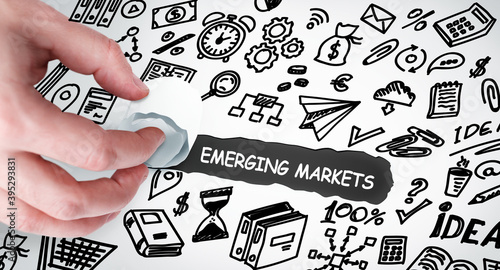 Technology, Internet and network concept. Young businessman shows the word: Emerging markets
