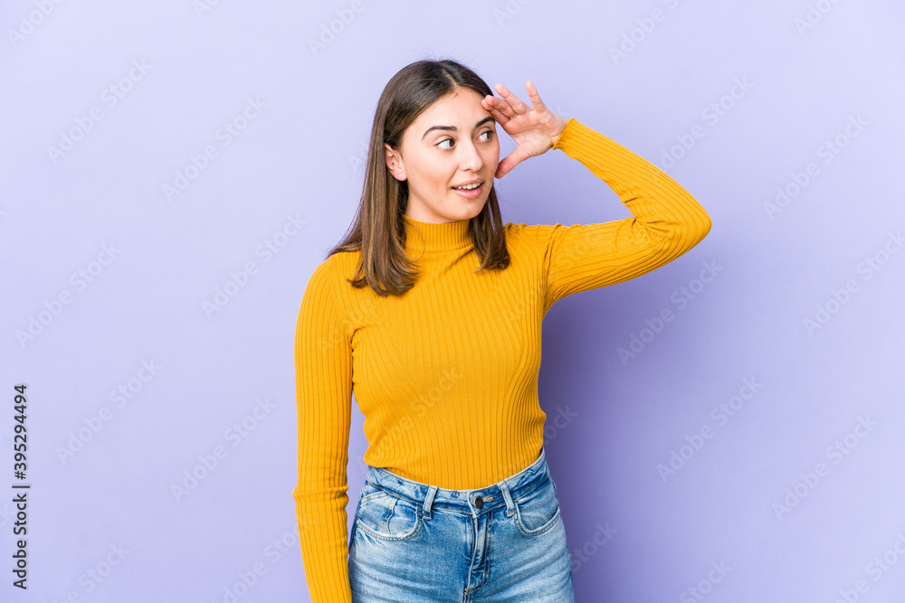 Young caucasian woman looking far away keeping hand on forehead. Young caucasian woman looking far away keeping hand on forehead.