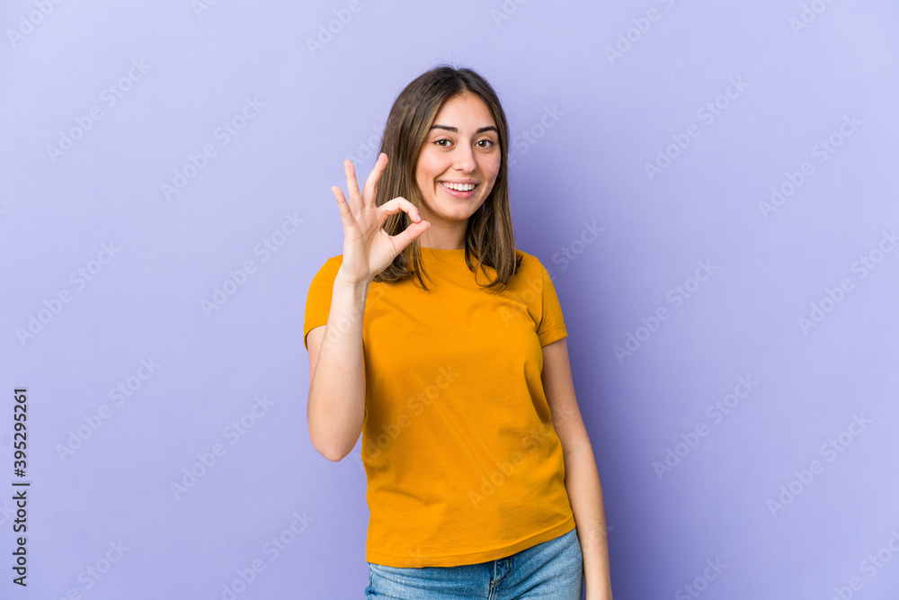 Young caucasian woman cheerful and confident showing ok gesture. Young caucasian woman cheerful and confident showing ok gesture.