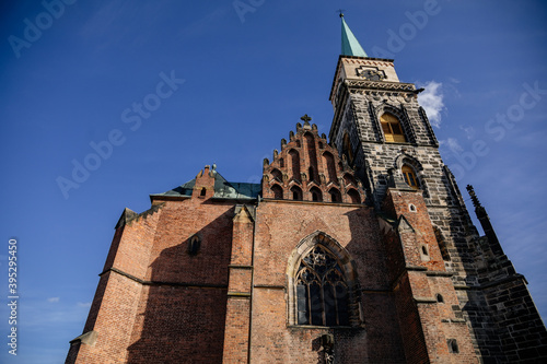 Medieval catholic church of Saint Jilji with gothic High clock tower in sunny autumn day, Nymburk, Central Bohemia, Czech Republic photo