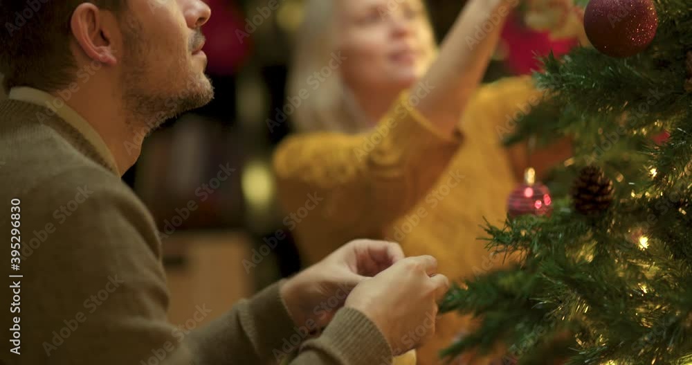 Young couple decorates Christmas tree Young couple decorates Christmas tree