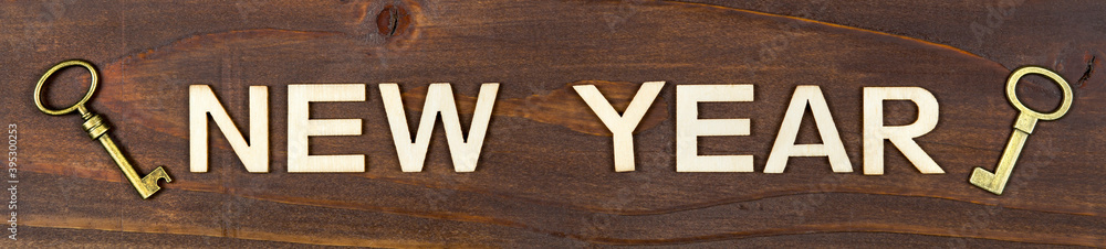 Happy new year letters with gold keys on wooden background, web banner Happy new year letters with gold keys on wooden background, web banner