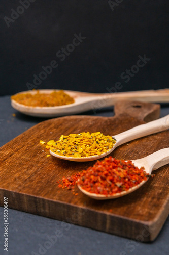dry spices in a wooden spoon close-up on a vintage background. selective focus