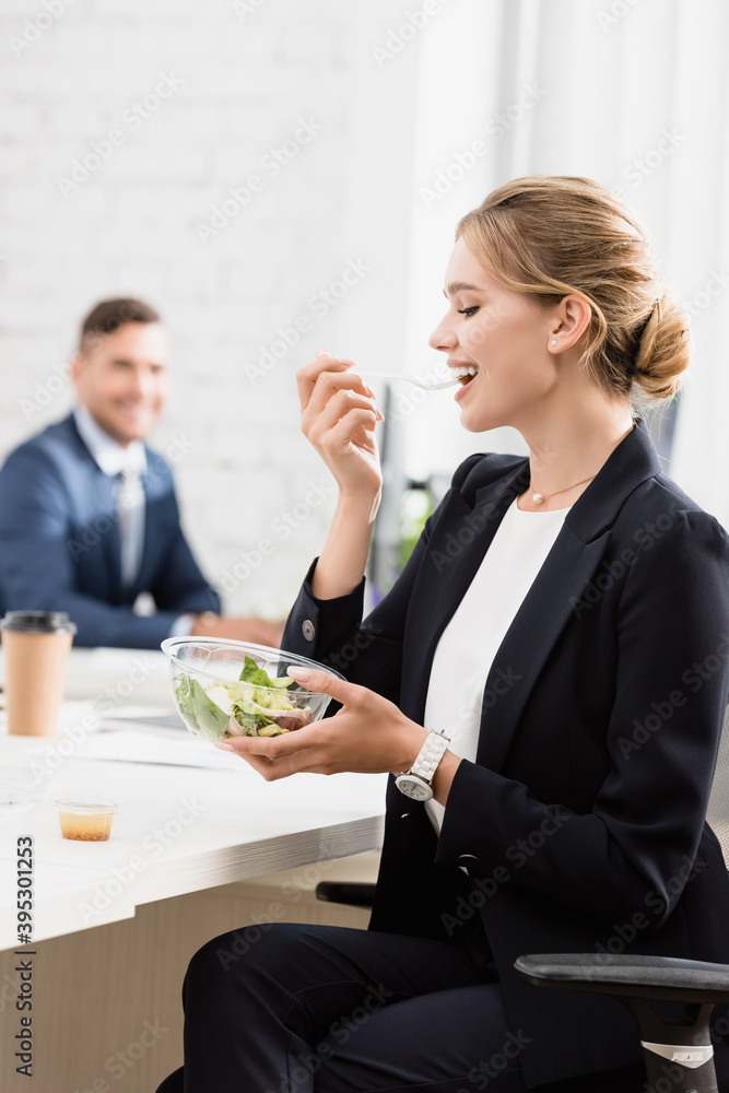 businesswoman eating meal from plastic bowl at workplace during break on blurred background businesswoman eating meal from plastic bowl at workplace during break on blurred background