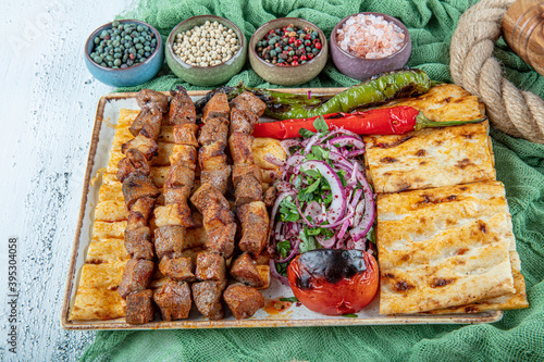 Turkish cuisine delicious ciger skewer. Liver skewer, Turkish Ciger Shish Kebab on small barbecue with tomatoes, delicious, natural, close-up looking. photo