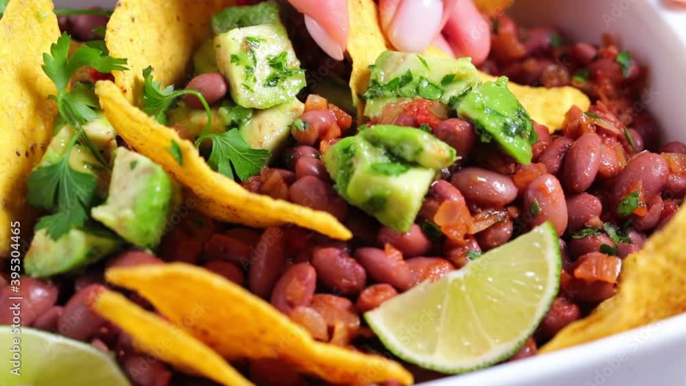 Bean salad with avocado and nachos in white dish. Mexican food concept. Bean salad with avocado and nachos in white dish. Mexican food concept.