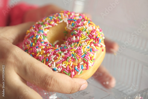 women hand holding fresh donuts close up 