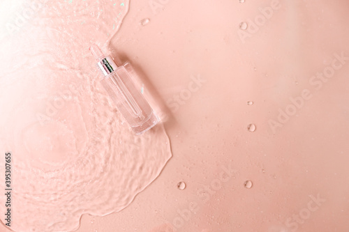 Glass Bottle with fluid collagen and hyaluronic acid, hydration skin. Top flatlay view copyspace. Abstract water background.