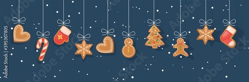 Gingerbread cookies hanging over winter snowy background.