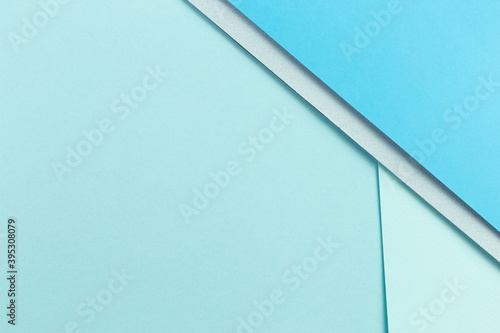 Material design blue background. Craft paper sheets are folded in different ways. A photo.