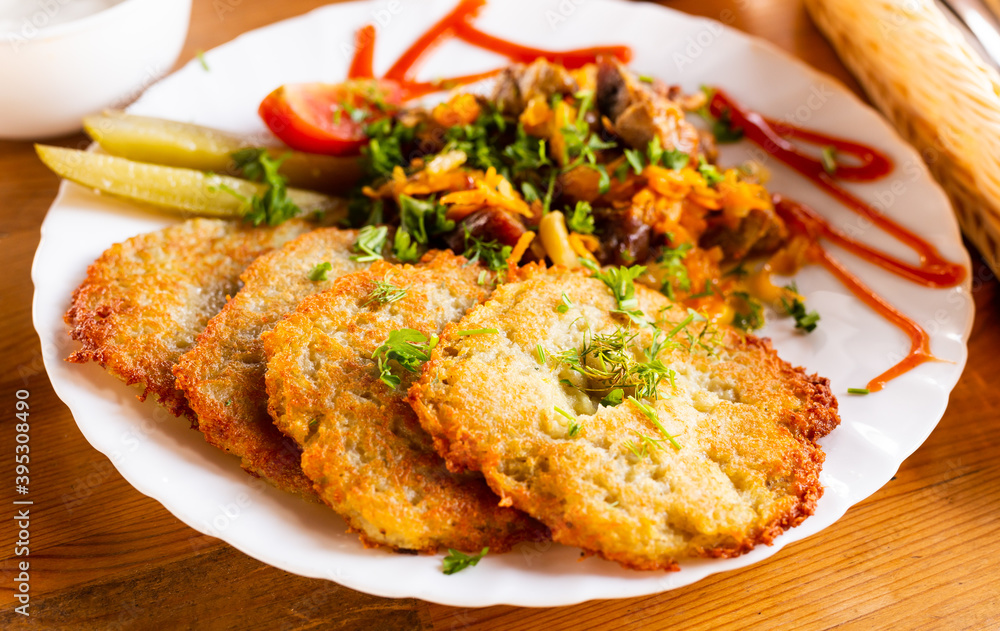 potato pancakes with grilled beef dish on a white plate