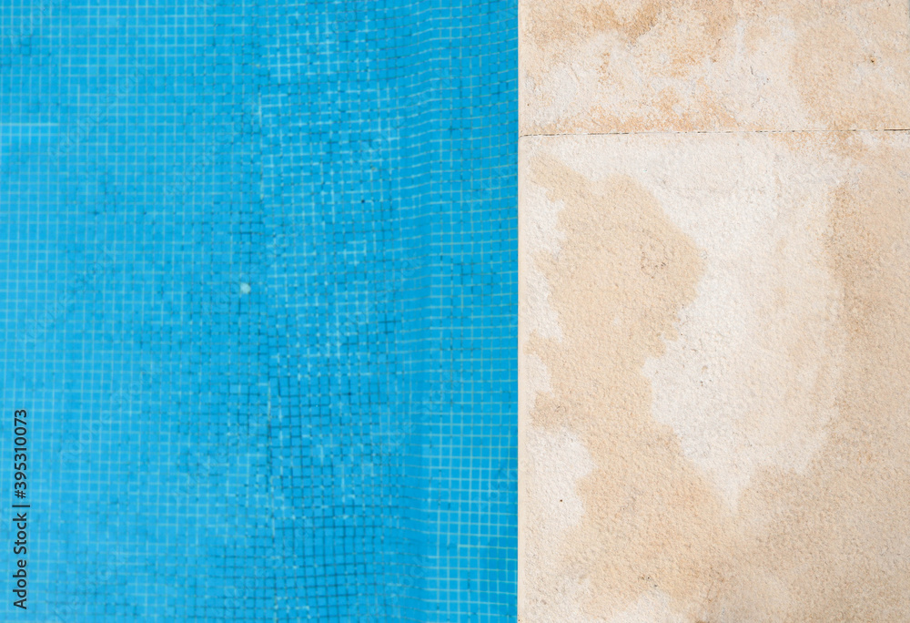 Fototapeta premium View from above at a swimming pool edge with blue water outdoors. Closeup horizontal photo