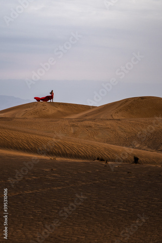 Frau mit rotem Kleid in der Wüste von Abu Dhabi