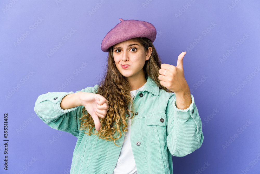 Young caucasian cute woman showing thumbs up and thumbs down, difficult choose concept Young caucasian cute woman showing thumbs up and thumbs down, difficult choose concept