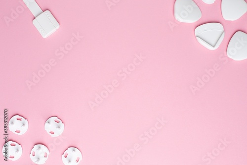 Plug on the electrical outlet and Protection for sharp corners on pink background, baby and children's safety