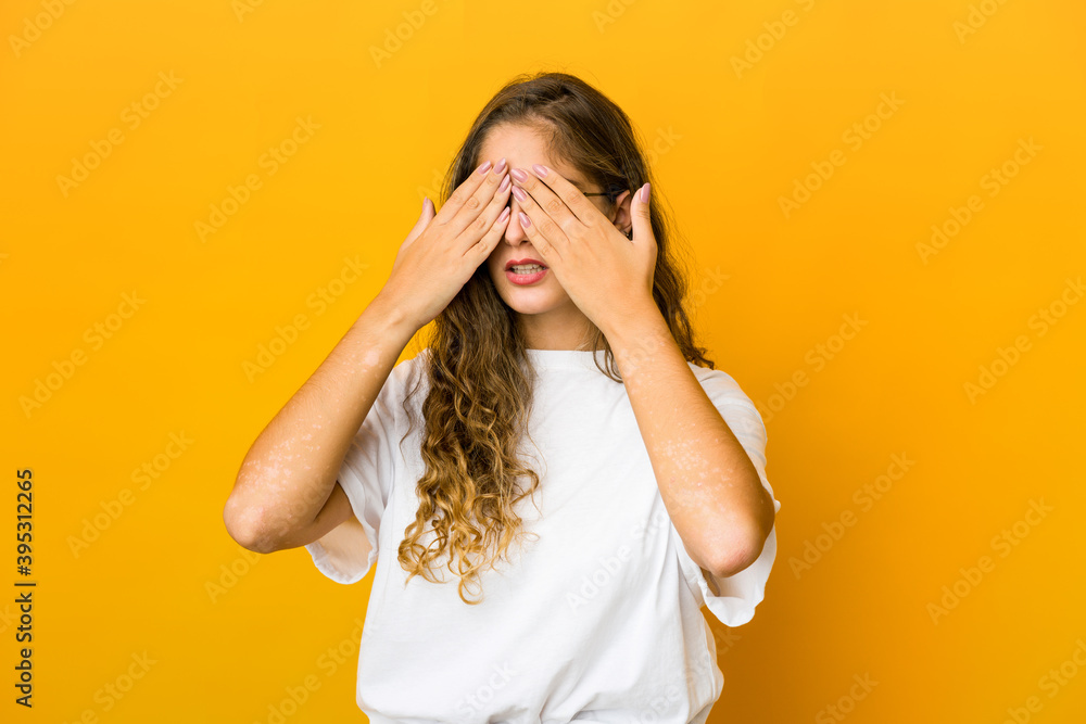 Young caucasian woman afraid covering eyes with hands. Young caucasian woman afraid covering eyes with hands.