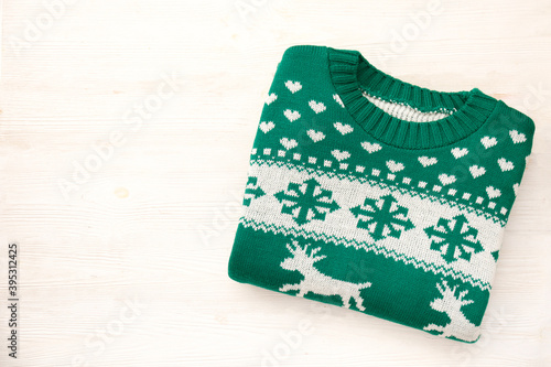 Ugly Christmas sweater concept. Festive jumper with deer and snowflake patterns isolated on white. Close up, top view, flat lay, copy space, background. photo