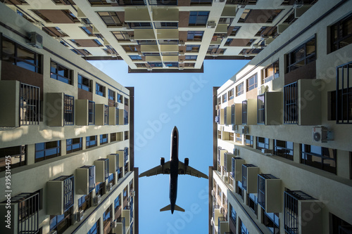 Big passenger plane over house. airplane is flying over building. bottom view