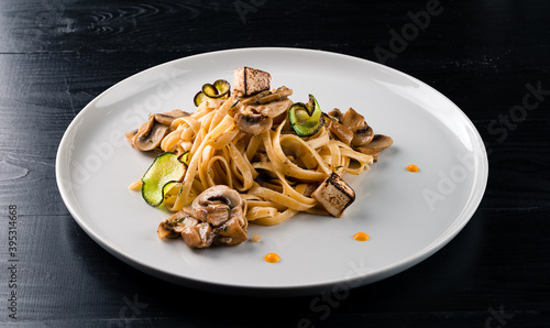 Linguine with mushrooms on a black table, Linguine with tofu