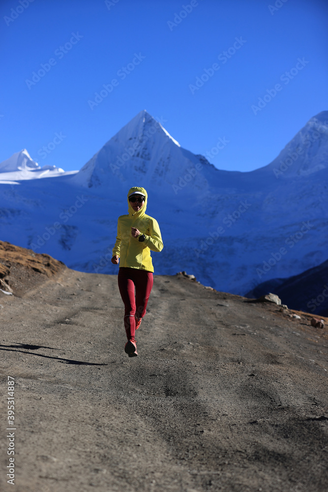 Fototapeta premium Woman trail runner cross country running in winter mountains