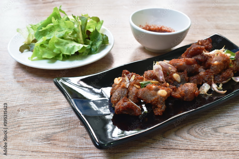 fried fermenting pork bone with crispy garlic on plate eat couple with fresh vegetable dipping spicy sauce fried fermenting pork bone with crispy garlic on plate eat couple with fresh vegetable dipping spicy sauce