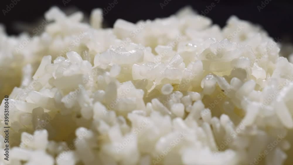 Cooked rice rotating on a turntable. Macro shot. Thai rice. Asian food. Cooked rice rotating on a turntable. Macro shot. Thai rice. Asian food.