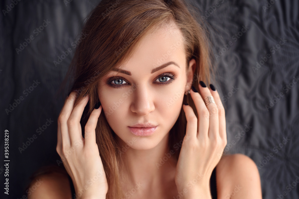 Portrait of a beautiful young woman with long hair looking at camera. Portrait of a beautiful young woman with long hair looking at camera.