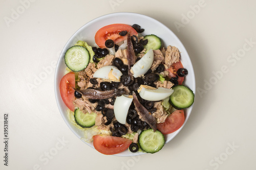 Mixed salad with tuna, anchovies and boiled eggs. photo