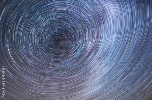 Beautiful starry sky with star trails orientation on the north star. Space background. Abstract long exposure background. 