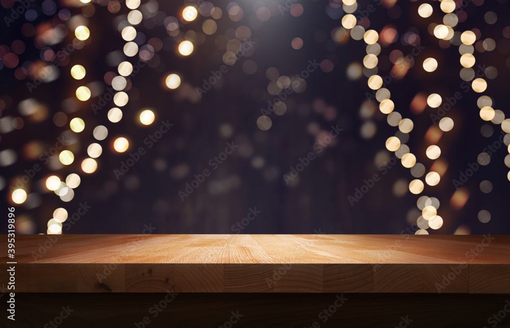 A wood table, tabletop product display with a festive Christmas background of hanging fairy lights against a dark backdrop.